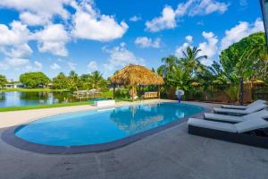 una piscina con tumbonas y un lago en Miami Paradise Waterfront Games, en North Miami Beach
