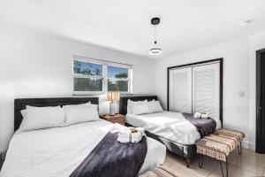 1 dormitorio con 2 camas, silla y ventanas en Miami Paradise Waterfront Games, en North Miami Beach 46 fotos más