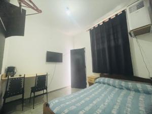 a bedroom with a bed and a desk and a television at rinconcito en floresta in Buenos Aires +2 photos