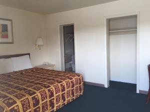 a hotel room with a bed and a closet at Coastal Motel in Jacksonville