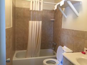 łazienka z wanną, toaletą i umywalką w obiekcie Coastal Motel w mieście Jacksonville