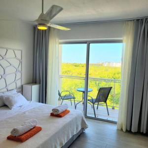 a bedroom with a bed and a balcony with a table and chairs at Vibe Residence Hotelstyle NO KITCHEN STUDIO close to beach in La Laguna