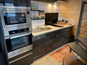 una cucina con lavello e fornello di Chalet chaleureux avec jacuzzi, parking et Wi-Fi aux Angles - FR-1-593-121 a Les Angles Altre 6 foto
