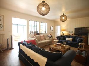 ein Wohnzimmer mit Sofas und einem Tisch in der Unterkunft Maison spacieuse près du lac avec piscine privée, idéal pour 16 personnes - FR-1-50-145 in Aureilhan