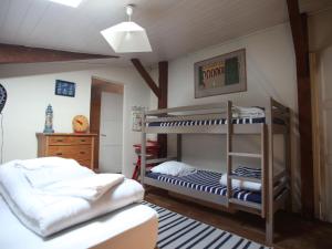 ein Schlafzimmer mit 2 Etagenbetten und einem Kinderbett in der Unterkunft Maison spacieuse près du lac avec piscine privée, idéal pour 16 personnes - FR-1-50-145 in Aureilhan