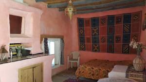 a bedroom with a bed and a table with a chair at Auberge Chez Julia in Merzouga