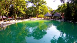 a large pool of green water with a gazebo at Hotel SPA Taninul in Los Puentes
