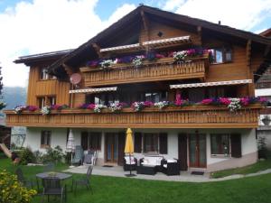 a house with a balcony with flowers on it at Chalet Petunia in Grächen