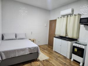 una piccola camera con letto e piano cottura di Casa de um cômodo tudo novo no boqueirão praia grande a Praia Grande