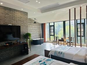 洛阳Qichi Waterfront B&B Hotel的一间卧室设有床铺、电视和砖墙