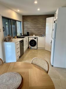 a kitchen with a refrigerator and a table with chairs at Beachside retreat in Caloundra