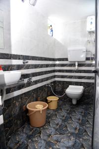 a bathroom with two sinks and a toilet and a sink at Om Villa in Mandvi +6 photos