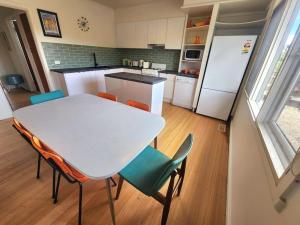 a kitchen with a white table and chairs and a white refrigerator at Rosebud Retro Retreat in Rosebud