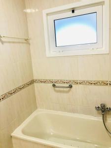 a white bath tub in a bathroom with a window at Cantinho de Algés in Algés