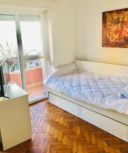 a bedroom with a bed and a desk and a window at Cantinho de Algés in Algés