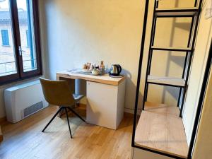 a room with a desk with a chair and a ladder at Il Carro Rooms - Monza Centro, Tribunale, Ospedale in Monza