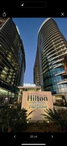 two tall buildings with a hotel sign in front of them at شقه فندقيه نيل هلتون ريزيدنس المعادي in Cairo