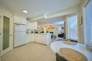 a kitchen with a white refrigerator and a table at Casa Pura Vida Hot Tub, Pool & Ping Pong Tables w Backyard & BBQ Come stay in Calgary