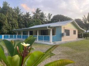 a small house with a blue roof at Sharnytas Guesthouse AIR CONDITIONED in Avarua