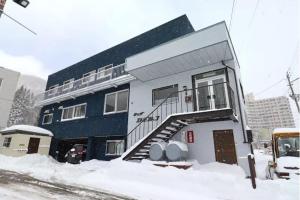 汤泽町lodge EDMONTON的一座有雪中楼梯的建筑