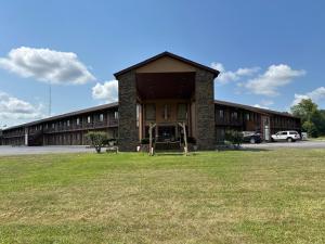 a building with a grass field in front of it at Park inn motel in Linton