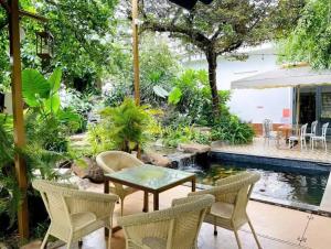 a patio with a table and chairs and a pond at Cherry homestay bmt phòng đôi gia đình in Buôn Ðũng