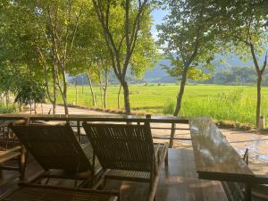 two chairs and a table with a view of a field at Truong Huy Homestay in Mai Chau