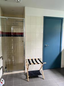 bagno con doccia e panca accanto a una porta blu di Uringah a Cowes