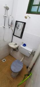a bathroom with a toilet and a sink at Anggerik Homestay in Kampong Batang Melekek