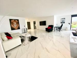 ein Wohnzimmer mit einem Löwengemälde an der Wand in der Unterkunft Villa Princesse neuve & grand standing ! in Valmont