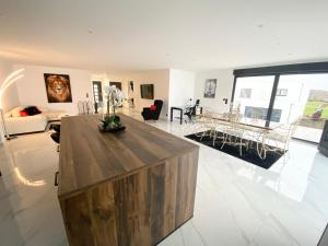 ein großes Wohnzimmer mit einem Holztisch in der Mitte in der Unterkunft Villa Princesse neuve & grand standing ! in Valmont