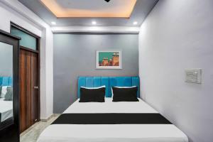 a small bedroom with a blue and white bed at Hotel O The smart haven in Ghaziabad