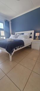 una cama en una habitación con una pared azul en Ocean Charm Swakopmund, en Swakopmund