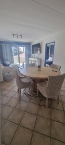 Una sala de estar con una mesa y sillas de madera. en Ocean Charm Swakopmund, en Swakopmund