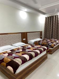 two beds in a hotel room with at Hotel Ajay Palace in Pīpalkoti