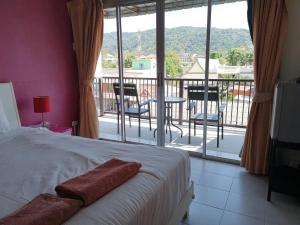a bedroom with a bed and a balcony with a view at Standard Room in Kata Beach