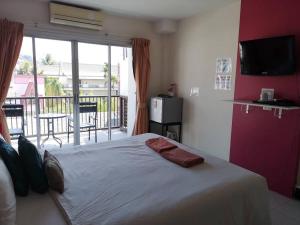 a bedroom with a large bed and a balcony at Standard Room in Kata Beach