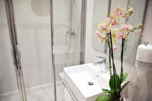 a bathroom with a sink and a vase with flowers at Il Giardino di Ghilot in Cherasco