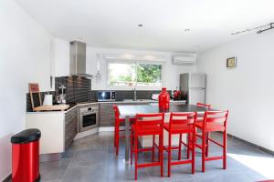 a kitchen with red chairs and a table in a kitchen at Appartement SAB in Issel