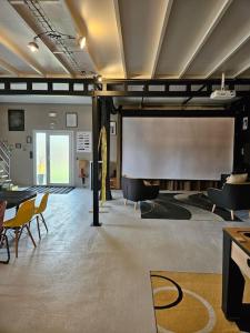 a large room with a projection screen and chairs at La salle de jeux in Saint-Lubin-en-Vergonnois +15 photos