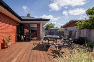 a patio with a table and chairs on a wooden deck at Comfort, quality, great location in Hamilton