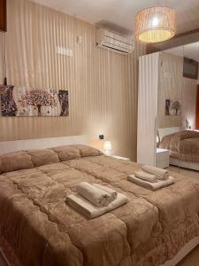 sypialnia z dużym łóżkiem i ręcznikami na nim w obiekcie Il Villino B&B - Napoli/Pompei/Sorrento/Costiera w mieście Brusciano