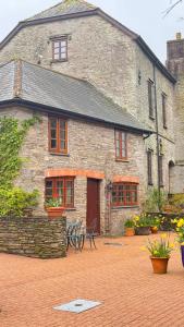 Un edificio de piedra con un banco delante. en Malston Mill Farm, en Kingsbridge
