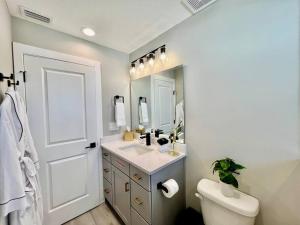 a bathroom with a sink and a toilet and a mirror at Modern Sanctuary in Saint Augustine in St. Augustine +63 photos