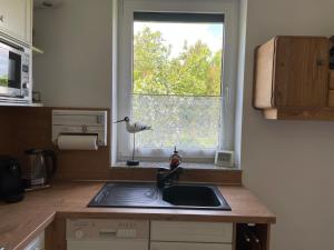 a kitchen with a sink and a window at Ferienhaus Amare mit Fasssauna, eigener Terrasse & Kamin in Bautzen +16 photos