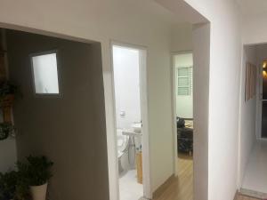a hallway with a bathroom and a sink in a room at Casa condomínio jardim Moncoes in Maringá +36 photos