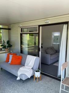 a living room with a couch and a living room with sliding glass doors at Jacks Place in Tauranga