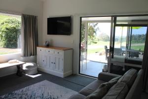 a living room with a couch and a sliding glass door at Jacks Place in Tauranga