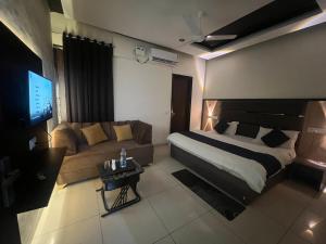 a hotel room with a bed and a couch at Wellawing Ferozpurn Road in Ludhiana +30 photos