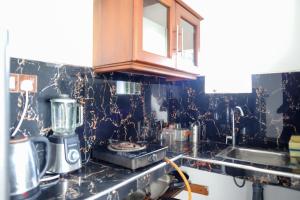 a kitchen with a black and gold counter top at Dream Next in Mirissa
